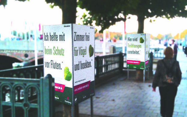 Bild einer Plattenkaschierung als Werbemaßnahme um einen Baumstamm