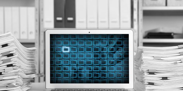 Laptop with digital archive program in office. Many folder icons and one highlighted on display